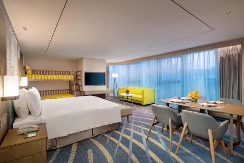 兰州兰州中心套房假日酒店的酒店客房带一张床、一张桌子和椅子