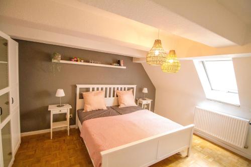 弗里肯豪森Main Idyll的一间卧室配有一张带粉色床单的床和一扇窗户。