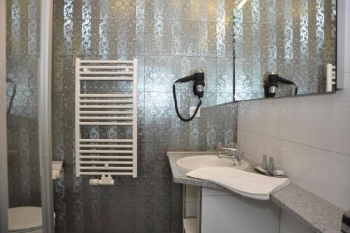 施马尔卡尔登Gästehaus Villa Casamia的一间带水槽和镜子的浴室