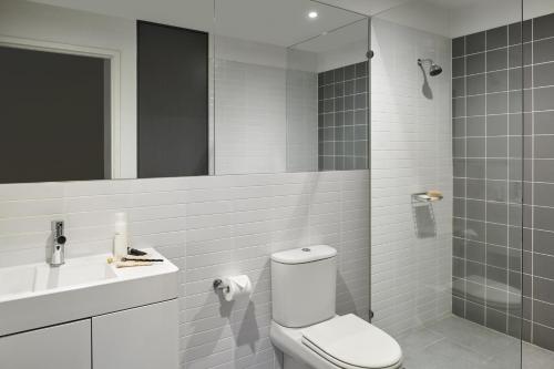 奥克利奥克利庞特山公寓酒店的一间带卫生间、水槽和镜子的浴室