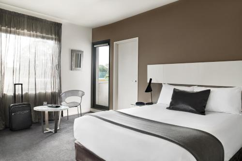 奥克利奥克利庞特山公寓酒店的一间卧室配有一张床、一张桌子和一个窗户。
