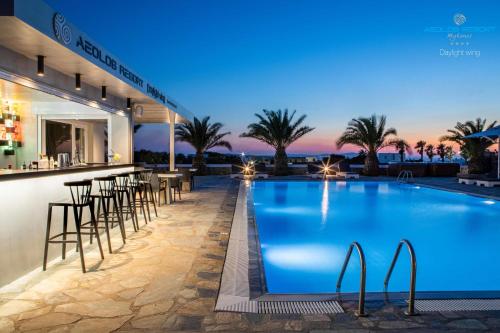 米克诺斯城Aeolos Resort的一家在晚上设有酒吧和游泳池的酒店