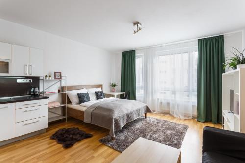 俄斯特拉发Golden Apartments Rezidence Nová Karolina的一间卧室配有床、电视和绿色窗帘