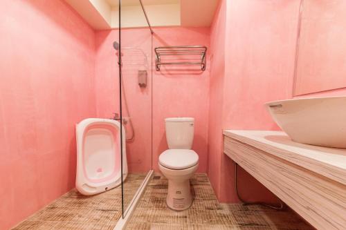 罗东镇罗东夜市坦智能旅店 的粉红色的浴室设有卫生间和水槽