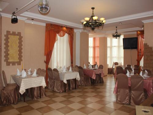 基兹洛沃茨克Hotel Atlantida的宴会厅配有桌椅和吊灯。