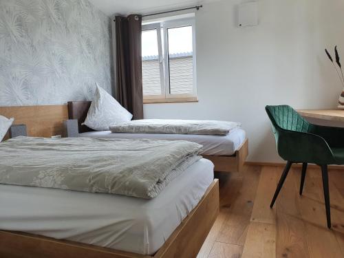 塞勒姆Ferienhaus am Funkenbühl的配有两张床铺的客房配有一张桌子和一把椅子
