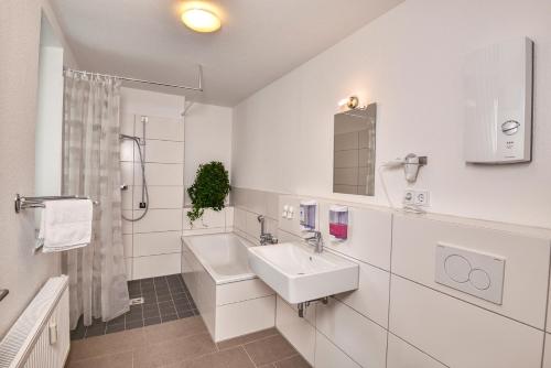 埃森Hostel am Niederfeldsee的白色的浴室设有水槽和淋浴。