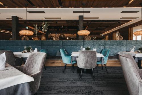 佩尔蒂绍瓦格纳霍夫酒店的餐厅设有白色的桌子和蓝色的椅子