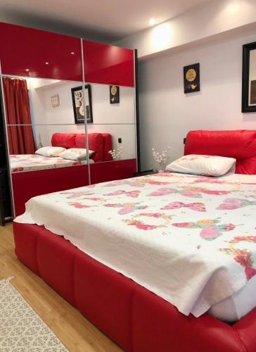 弗格拉什Bella Casa Apartments的一间卧室配有一张红色大床和镜子
