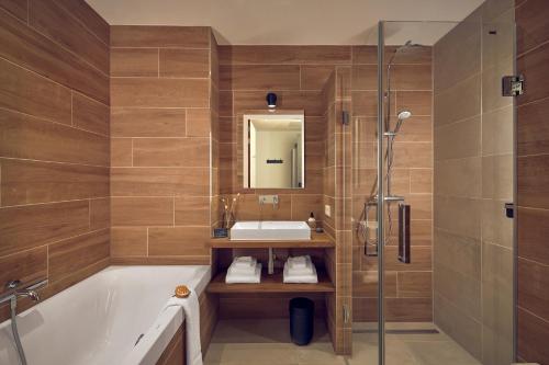 费尔普Boutique Hotel Beekhuizen的带浴缸、水槽和淋浴的浴室