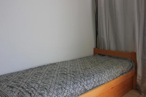 圣伊莱尔德里耶St Hilaire de Riez - 500m de la plage des Becs的一张小床,位于带窗帘的房间