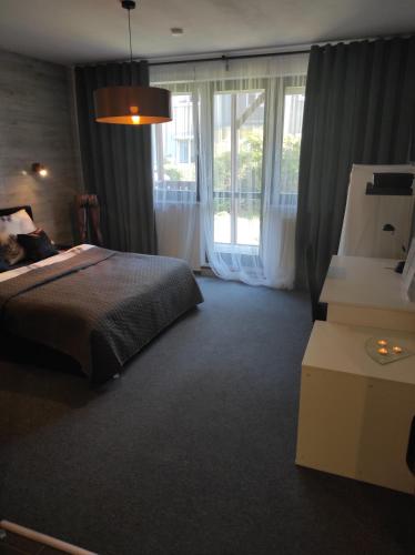 格但斯克Heliosa Apart Gdańsk Kowale的一间卧室设有一张床和一个大窗户