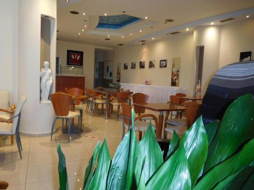 卢特拉艾季普苏Efstratios Hotel的一间带桌椅和雕像的餐厅
