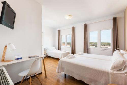 马翁Hostal Jume - Urban Rooms的酒店客房配有两张床和一张书桌