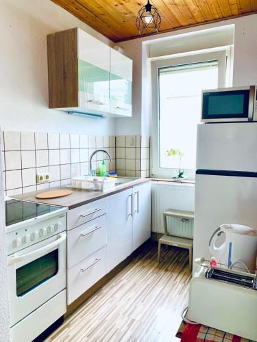 门兴格拉德巴赫Apartment Apfel的一间厨房,配有白色家电和木制天花板