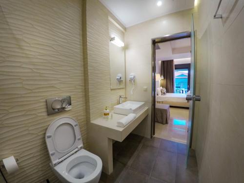萨尔蒂Arion suites的一间带卫生间、水槽和镜子的浴室