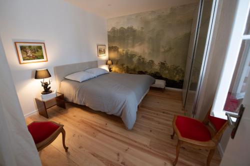 波尔多独特度假屋的卧室配有一张床,墙上挂有绘画作品