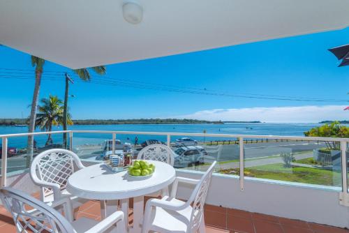 努萨维尔穆尼纳海滩公寓酒店的阳台配有桌椅,享有海景。
