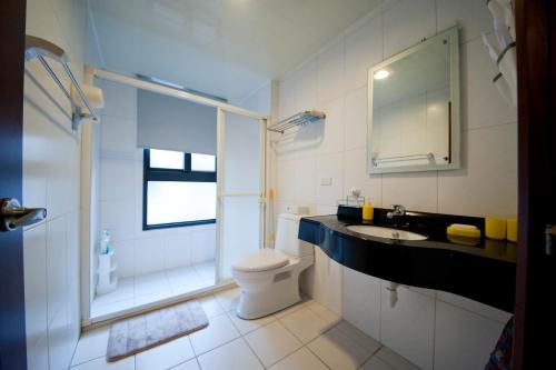 高雄左营高铁-旅行舍的浴室配有卫生间、盥洗盆和淋浴。