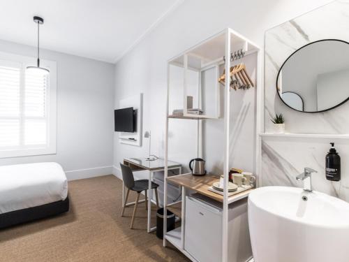 悉尼巴克斯利邦迪旅馆的一间卧室配有床、水槽和镜子