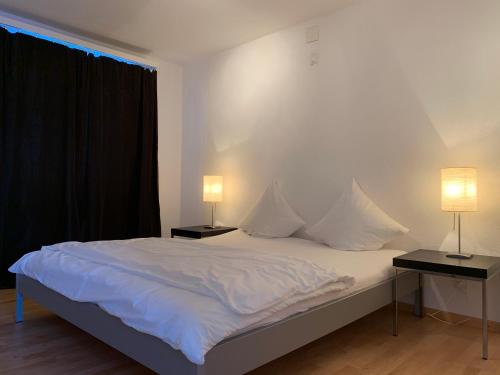 达沃斯Vinadi的卧室配有带两盏灯的白色床