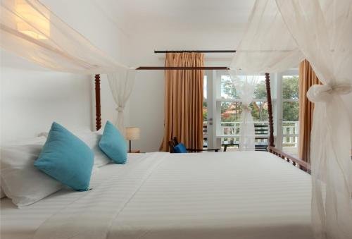 暹粒Amber Angkor Villa Hotel & Spa的卧室配有带蓝色枕头的大型白色床