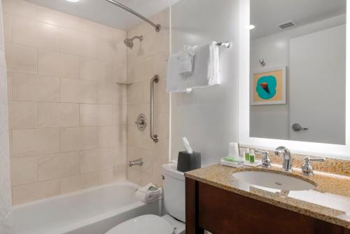 奥兰多Holiday Inn Orlando – Disney Springs™ Area, an IHG Hotel的带浴缸、卫生间和盥洗盆的浴室