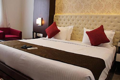 阿格拉泰姬陵高地酒店的一张大床,位于酒店客房内,配有红色枕头