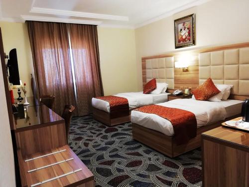 吉达罗山艾尔阿扎酒店的酒店客房配有两张床和一张书桌