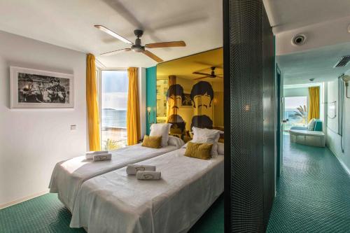 普拉亚登博萨Dorado Ibiza - Adults Only的一间卧室配有一张大床和吊扇