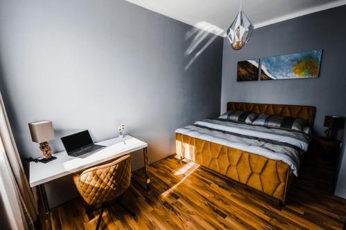 施泰尔Design-Appartement Steyr的一间卧室配有一张床和一张带笔记本电脑的书桌