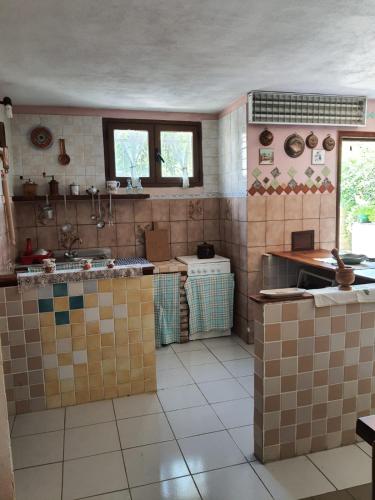 SolèminisDwelling Zara的厨房的墙壁上设有瓷砖和水槽。