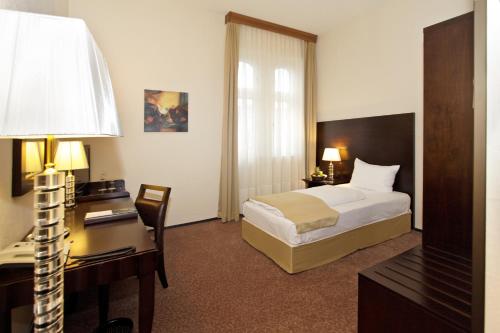 汉诺威Grand Palace Hotel Hannover的配有一张床和一张书桌的酒店客房