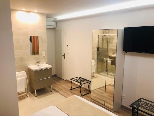 蒂耶尔Pavillon Fani的带淋浴和盥洗盆的浴室以及电视。
