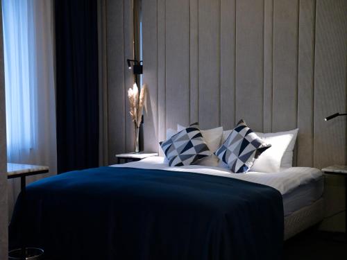 布加勒斯特Union Plaza Hotel的一间卧室配有一张带蓝色和白色枕头的床