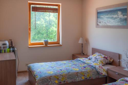 Jaunmārupekafejnīca Laura的一间卧室设有一张床和一个窗口