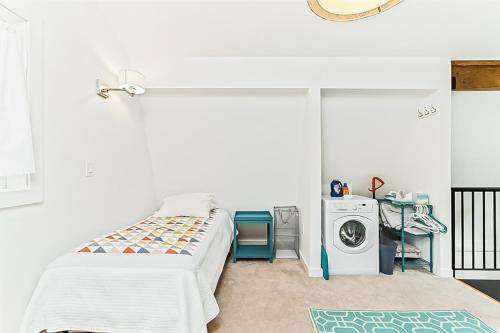 哥德伍德Kabina on Vail的白色的客房配有床和洗衣机。