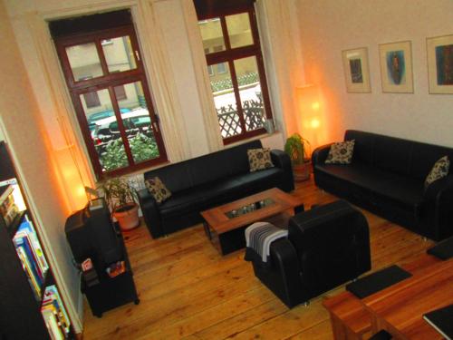 柏林静谧度假屋 - 柏林米特区的客厅配有两张黑色沙发和一张桌子