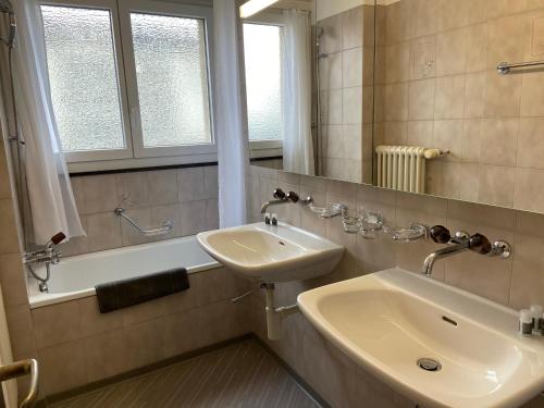 Uzwil豪斯2号服务式公寓的浴室配有盥洗盆和浴缸。