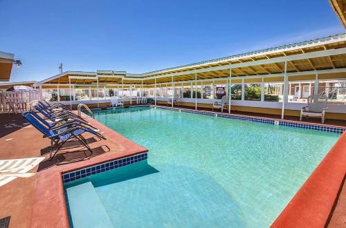 科帕利斯比奇Beachwood Condos & Resort的大楼内带蓝色椅子的大型游泳池