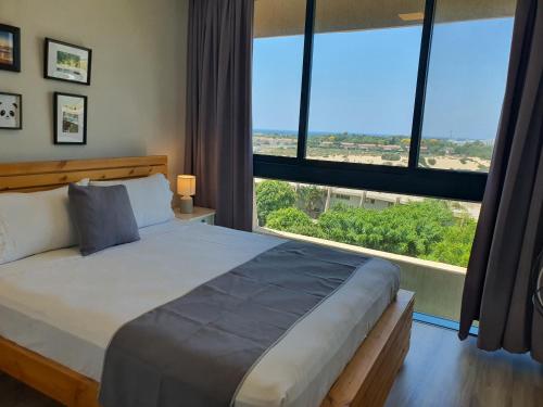 凯撒利亚Boutique Apartments Caesarea的一间卧室设有一张大床和大窗户