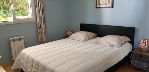 盖塔里GUETHARY APPARTEMENT PLAIN PIED PROCHE PLAGE CENITZ的卧室内的一张带两个枕头的大床