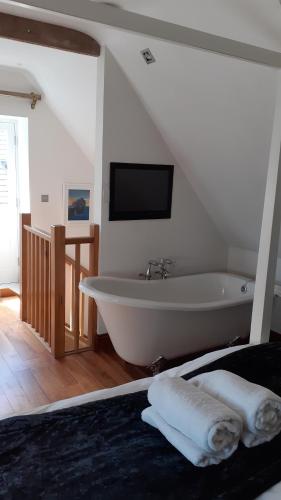 Cerne AbbasThe New Inn的带浴缸的浴室和墙上的电视