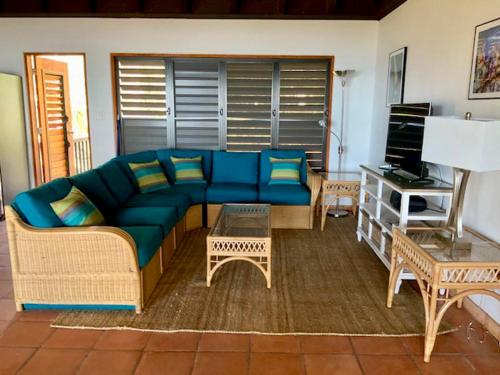 维尔京戈尔达岛VILLA DEL SOLE的客厅配有蓝色的沙发和桌子