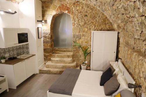 赫罗纳Girona Catedral的一间卧室设有一张床和石墙
