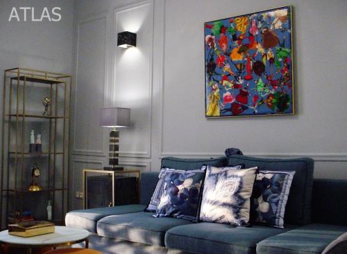 科孚镇Corfu Unreal View Flats的客厅配有蓝色沙发和绘画作品