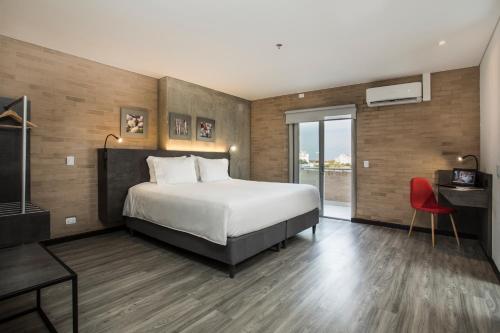 卡利Hotel Quinta Norte Chipichape的酒店客房设有一张床和一个大窗户