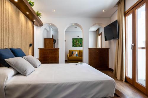 科尼尔-德拉弗龙特拉Hotel Antantie的卧室配有一张白色大床和电视。