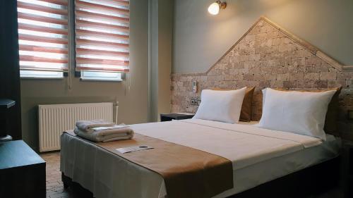 泰基尔达Royal Park Hotel Corlu的一间卧室设有一张带砖墙的大床