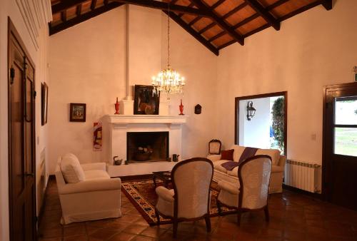 圣洛伦索Posada de los Poetas Hotel Boutique的客厅配有桌椅和壁炉